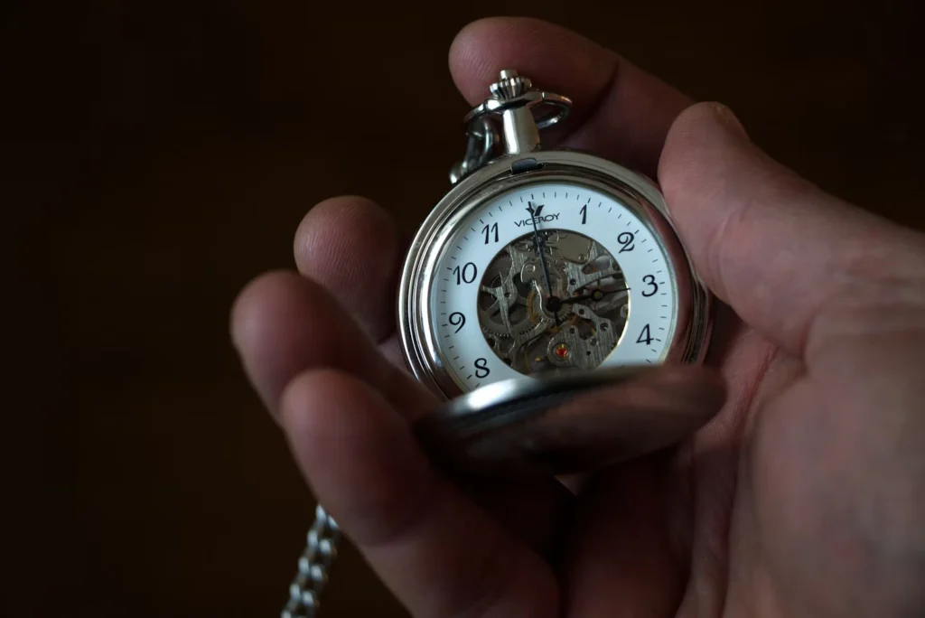 a hand holding a old style watch with the cover opened Late Rent Payments