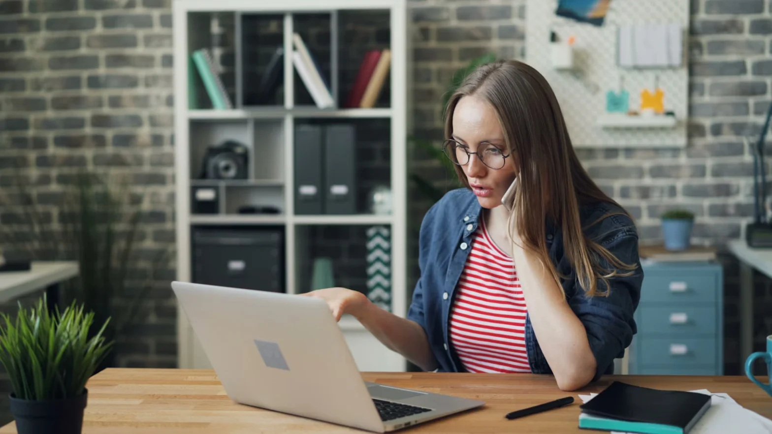 girl looking at her laptop while taking a call with her mobile phone tenant screening issues