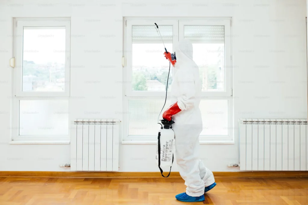 a pest control man fully equipped protection holding a spray gun for insects Pest Infestations
