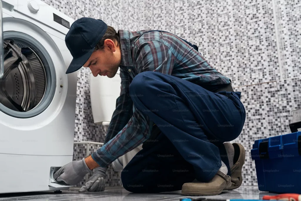 repair guy fixing washing machine